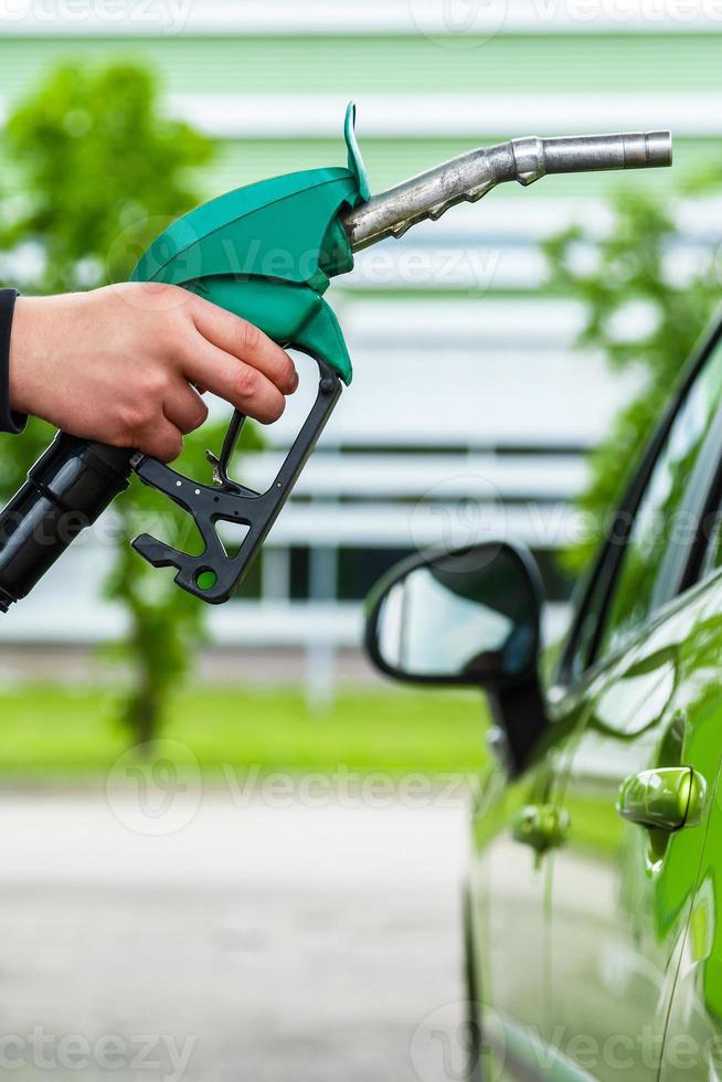 Man fills up his car with a gasoline photo