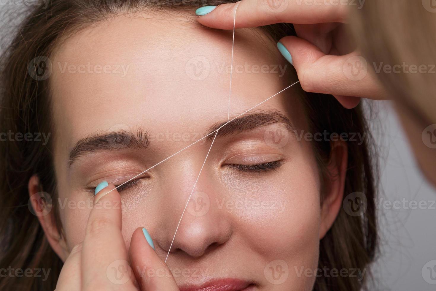 Eyebrow correction with a white thread photo