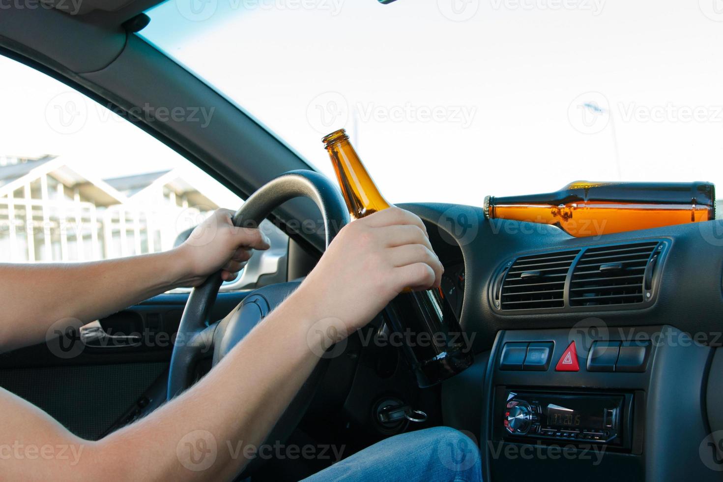 Car driver holding a bottle of beer photo