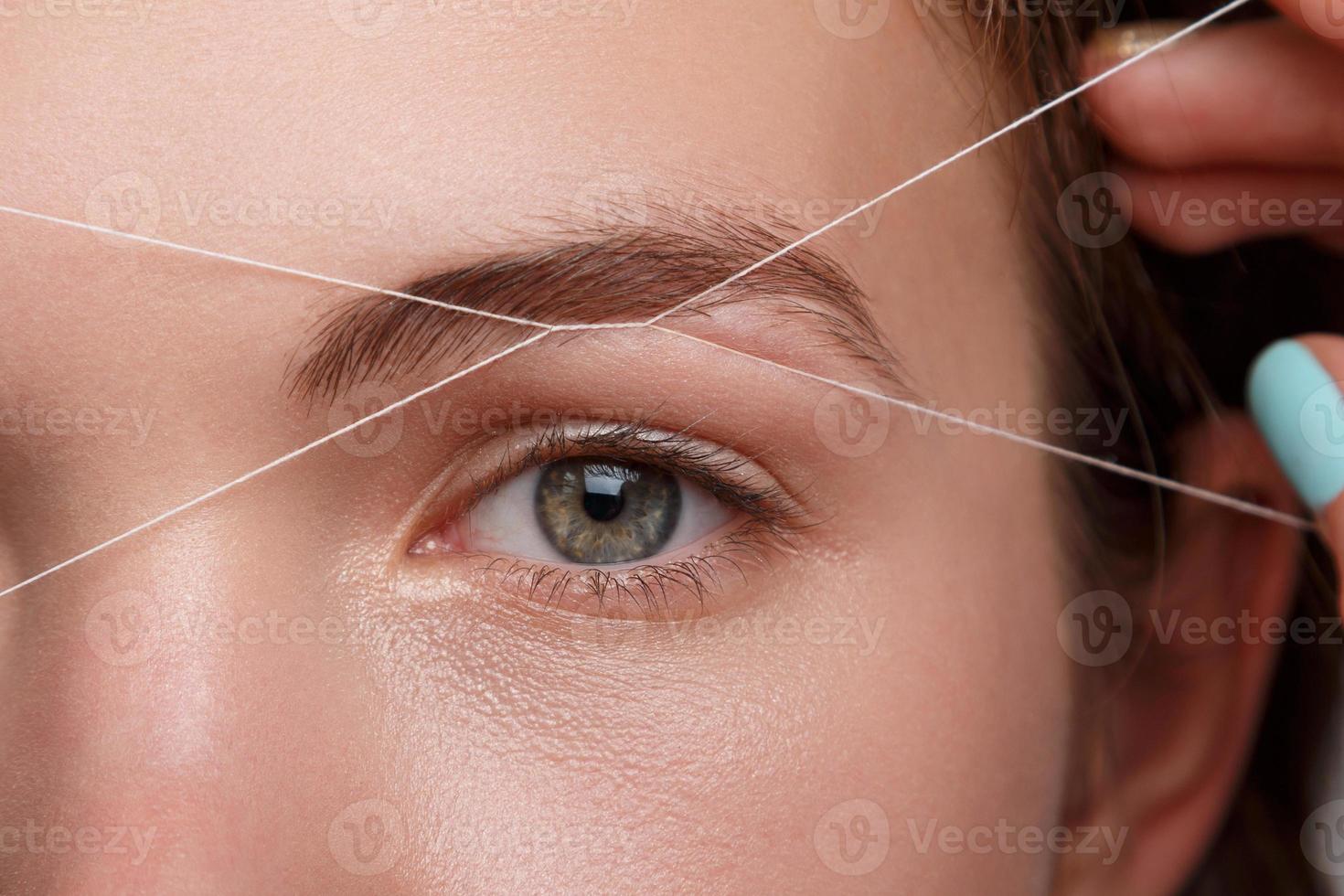 Eyebrow correction with a white thread photo