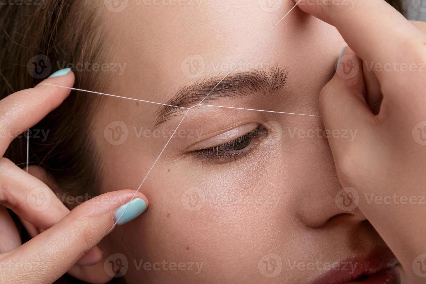 Eyebrow correction with a white thread photo