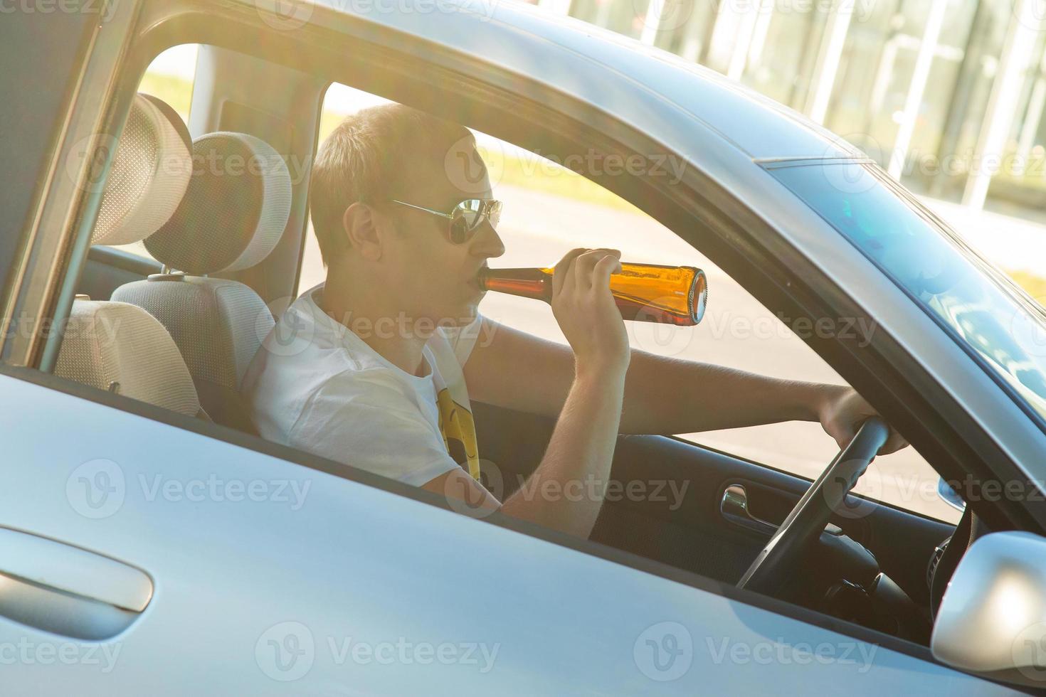 Man is drinking beer in his car photo