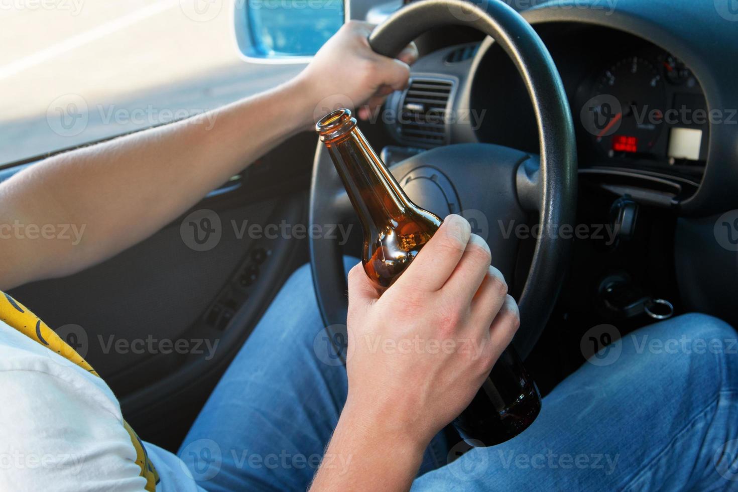 conductor de auto sosteniendo una botella de cerveza foto