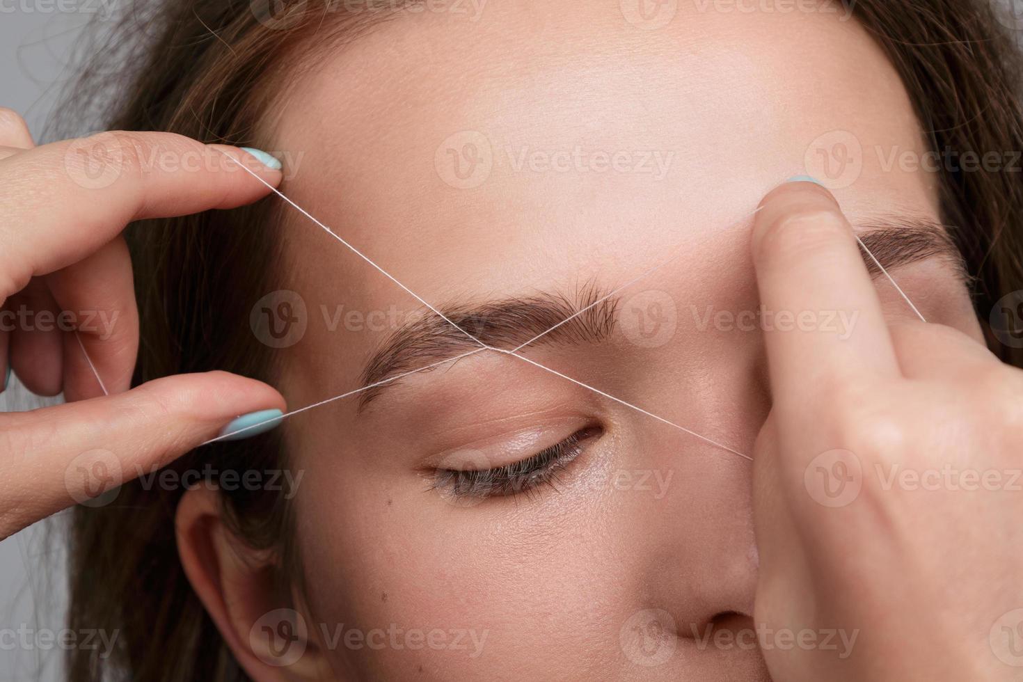 Eyebrow correction with a white thread photo