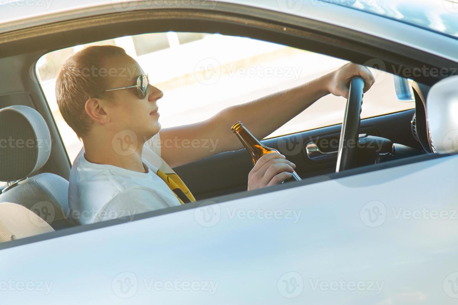 Man is drinking beer in his car photo