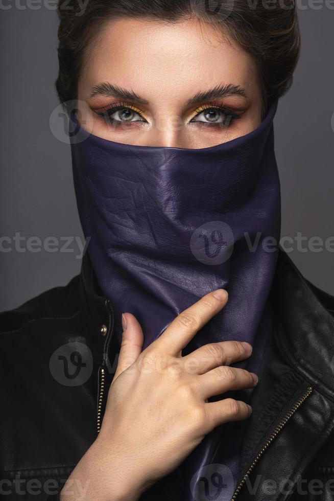 Portrait of stylish woman wearing leather neck gaiter instead of prevention mask. photo