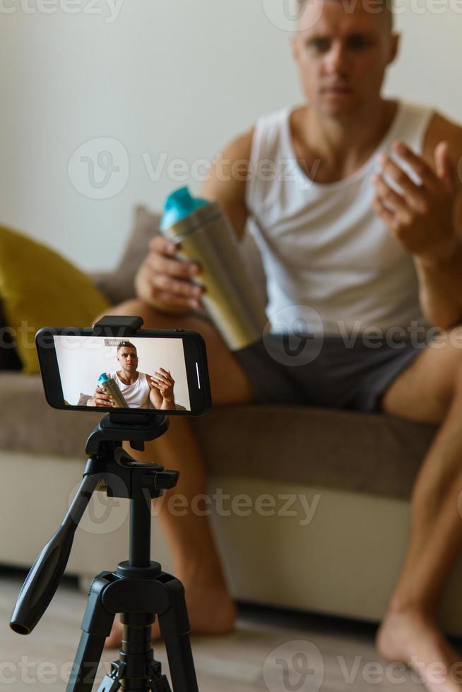 Fitness blogger streaming or recording video for his subscribers photo