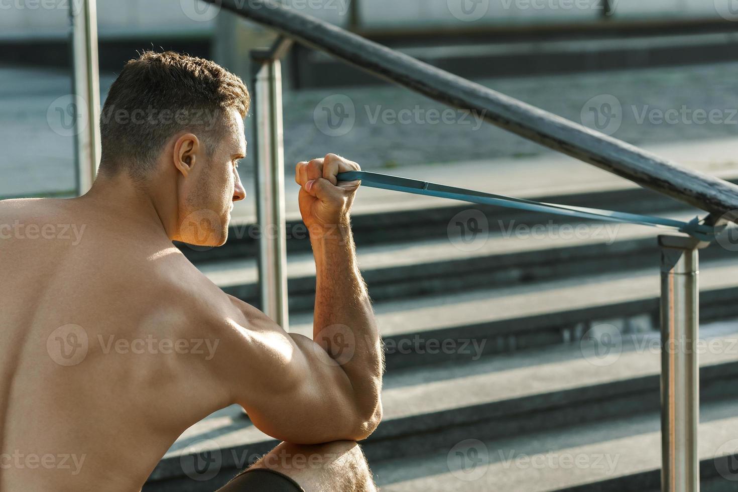 hombre musculoso durante el entrenamiento con una banda de goma de  resistencia en una calle 16290649 Foto de stock en Vecteezy