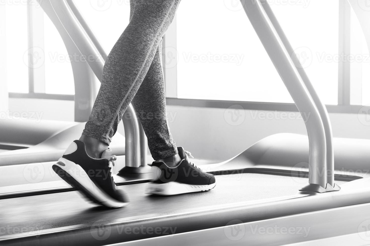 Female legs on a treadmill with motion blur effect photo