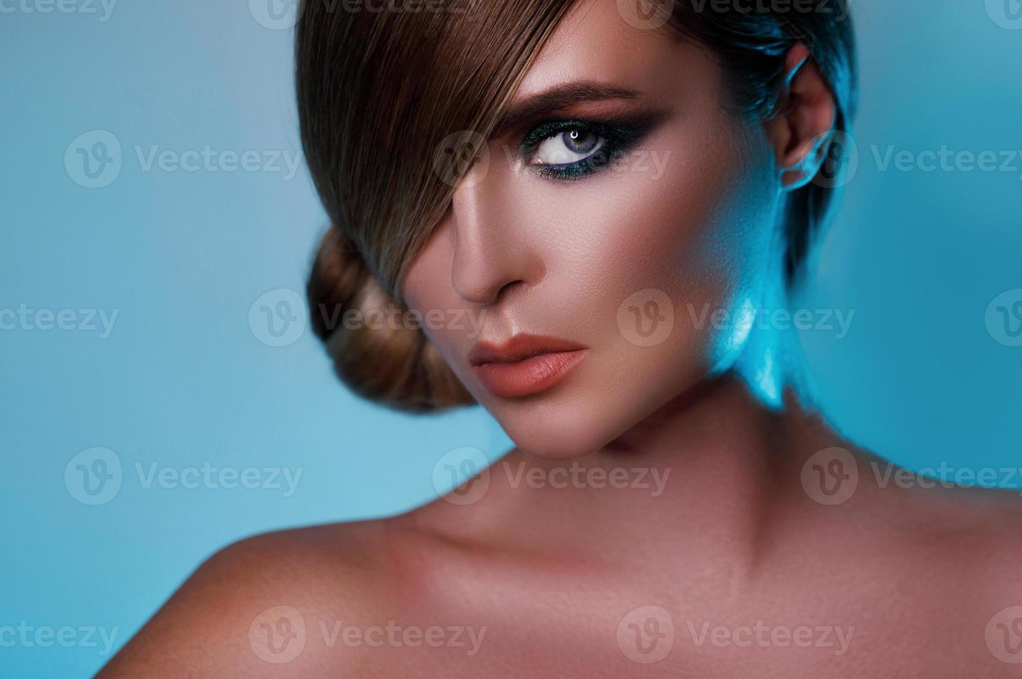 Model in stylish image with sleek hair covering one eye and beautiful green eyeshadows on another photo