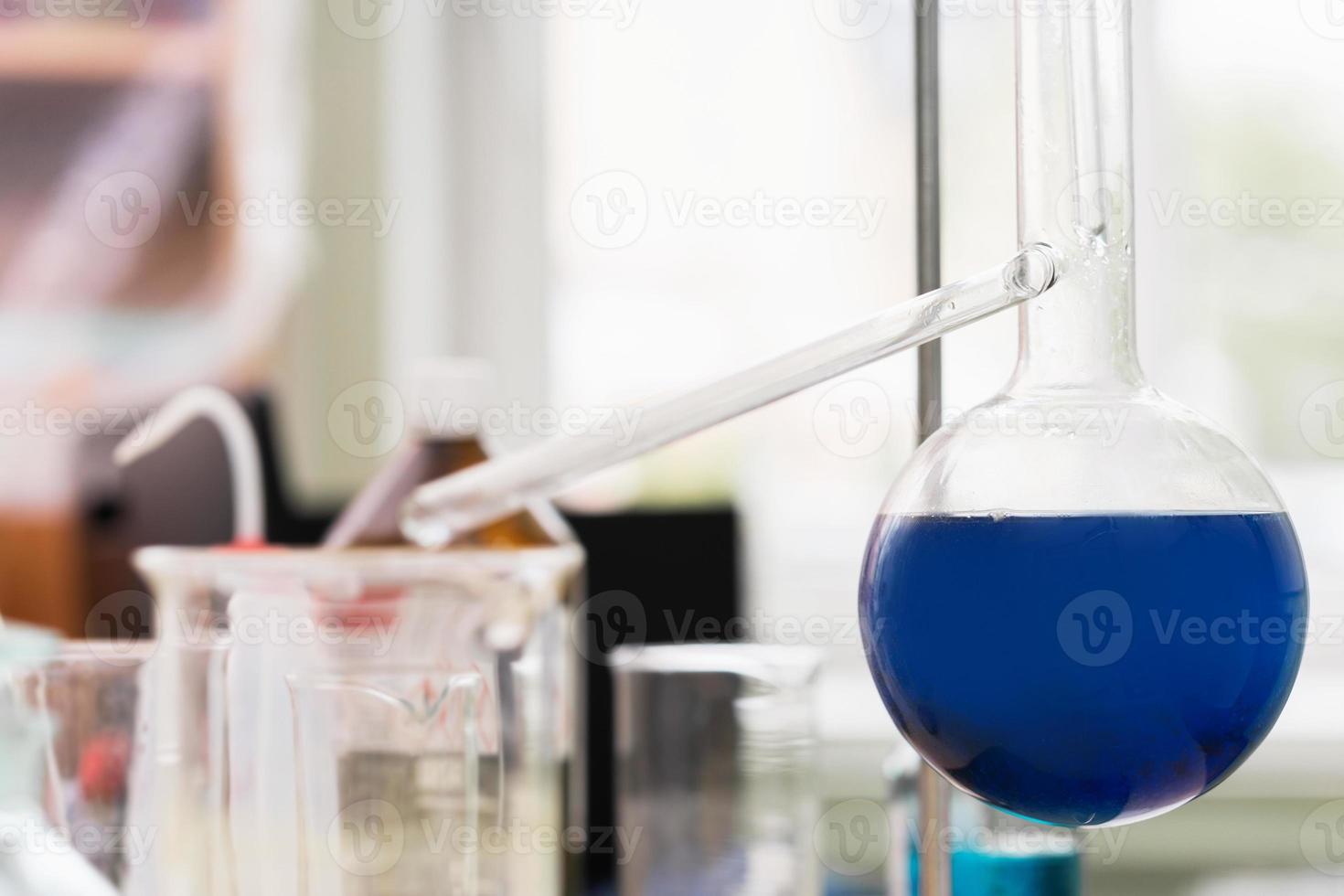 Retort flask filled with a blue substance in a laboratory photo