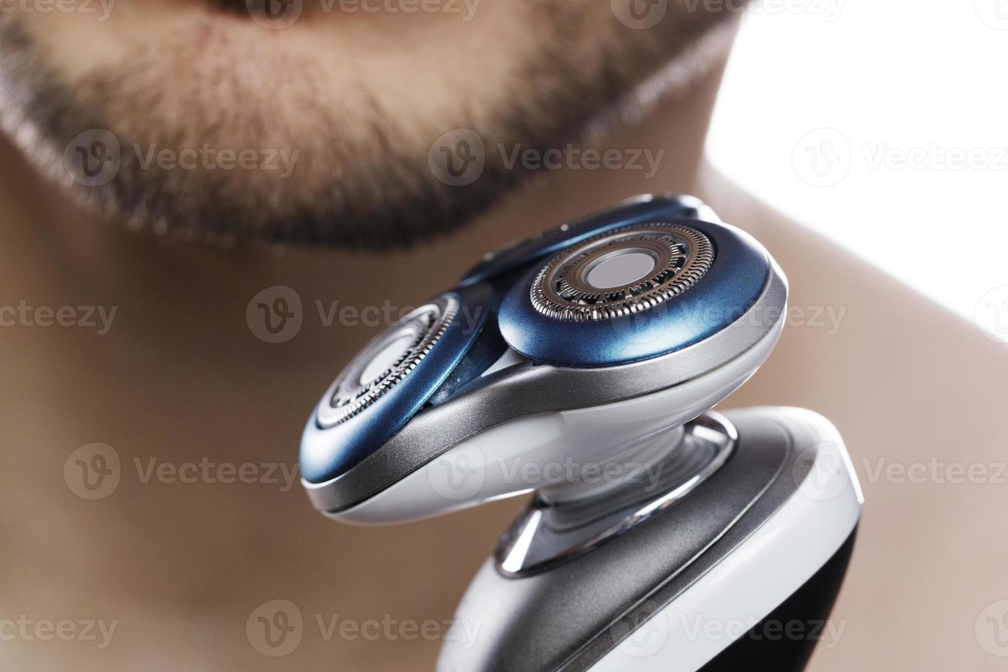 Close up of male chin and modern electric shaver photo