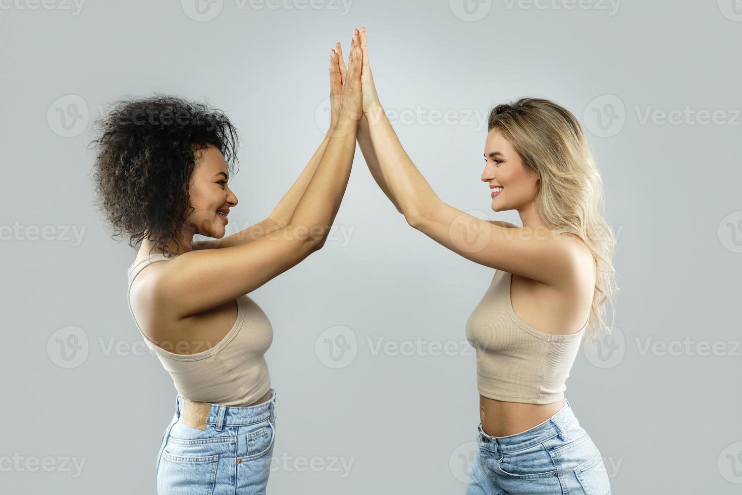 A high five between Caucasian and African American women. Concepts interracial friendship or lesbian relationship. photo