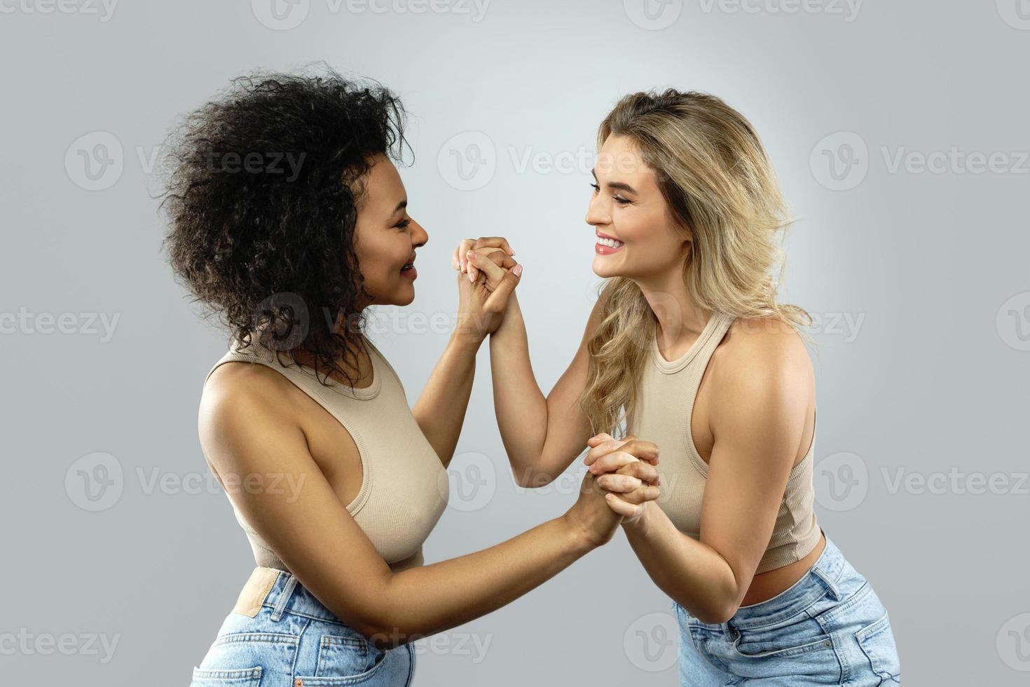 Caucasian and African American women holding hands. Concepts interracial friendship or lesbian relationship. photo