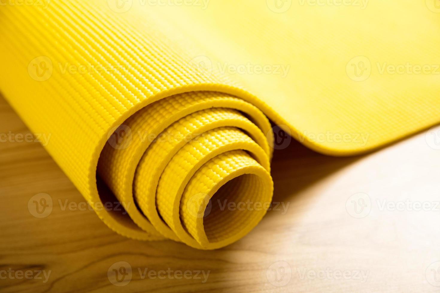 Close-up of yellow fitness mat on the floor photo