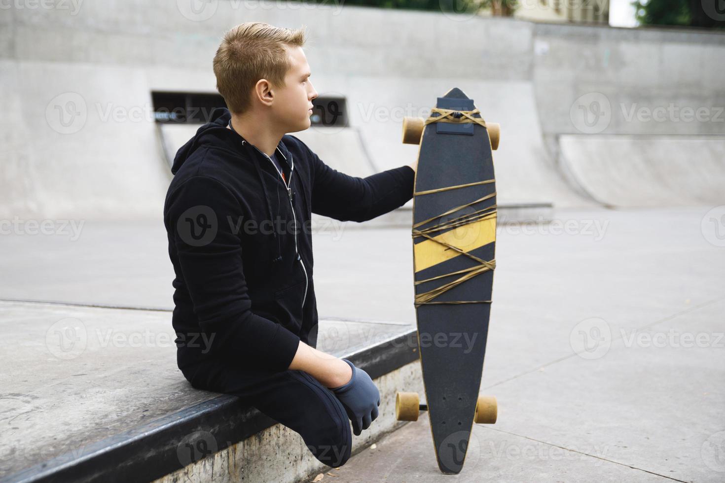 joven discapacitado con un longboard en un skatepark foto