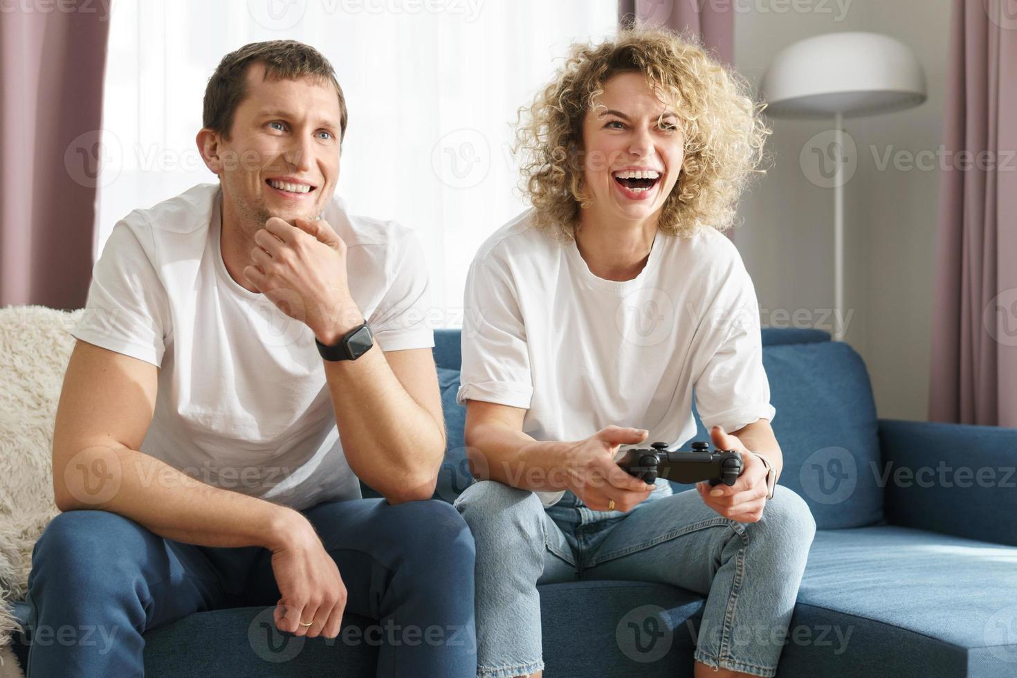 una pareja con gamepads está jugando una consola de videojuegos foto