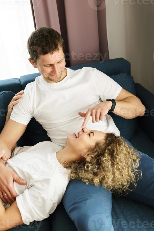 Happy couple relaxing on the sofa at home photo