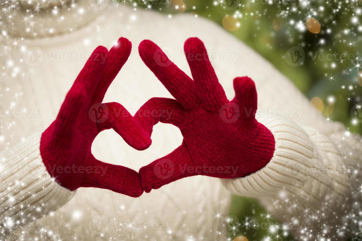 Woman Wearing Red Mittens Holding Out a Heart Hand Sign photo