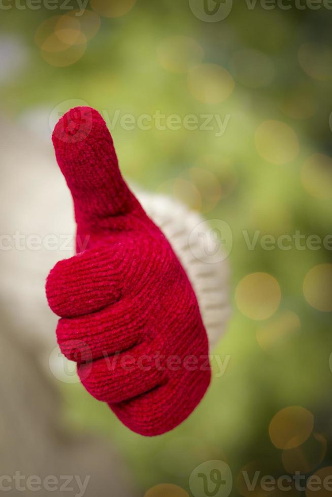 Woman Wearing Red Mittens Holding Out Thumbs Up Hand Sign photo