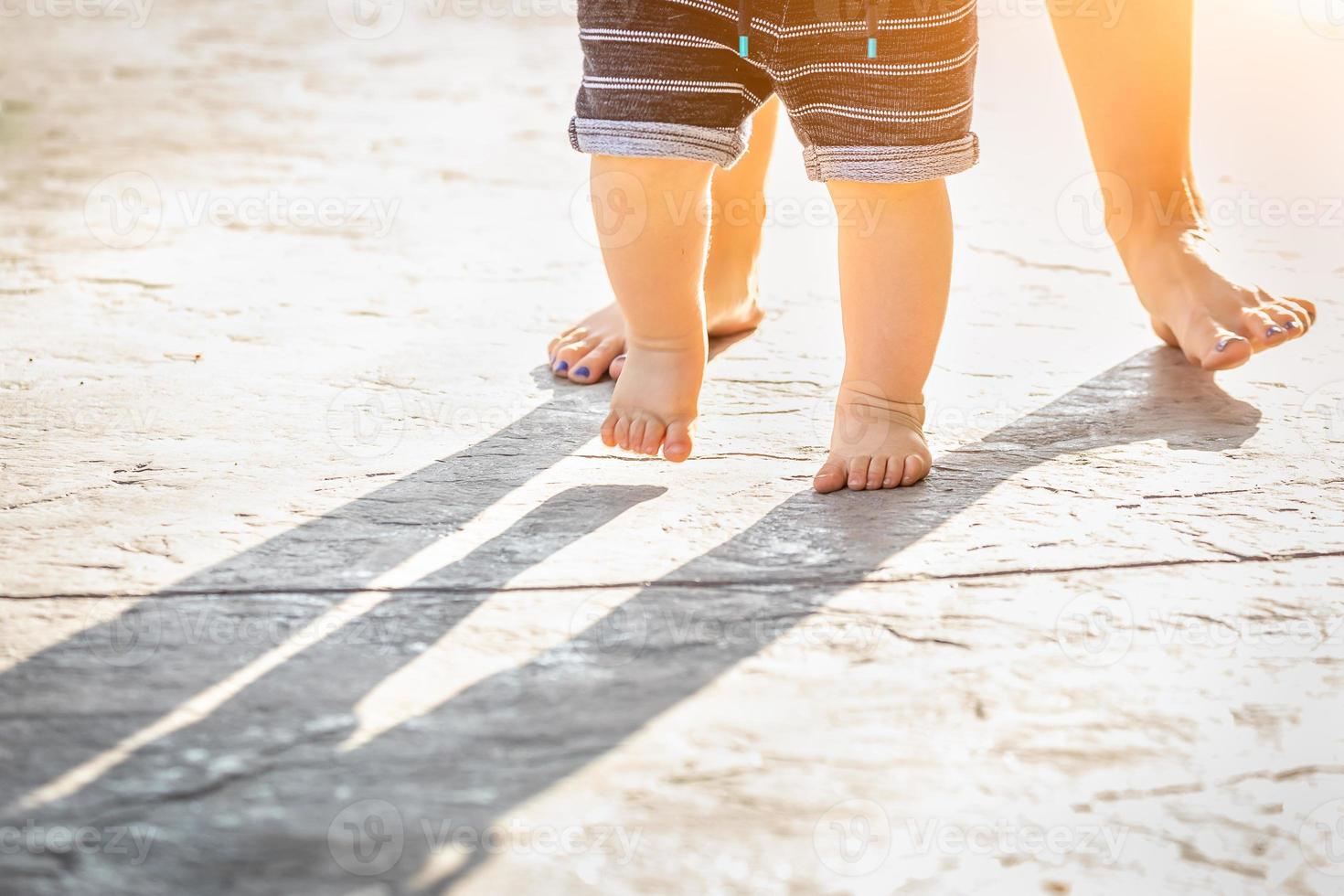 pies de madre y bebé dando pasos al aire libre foto
