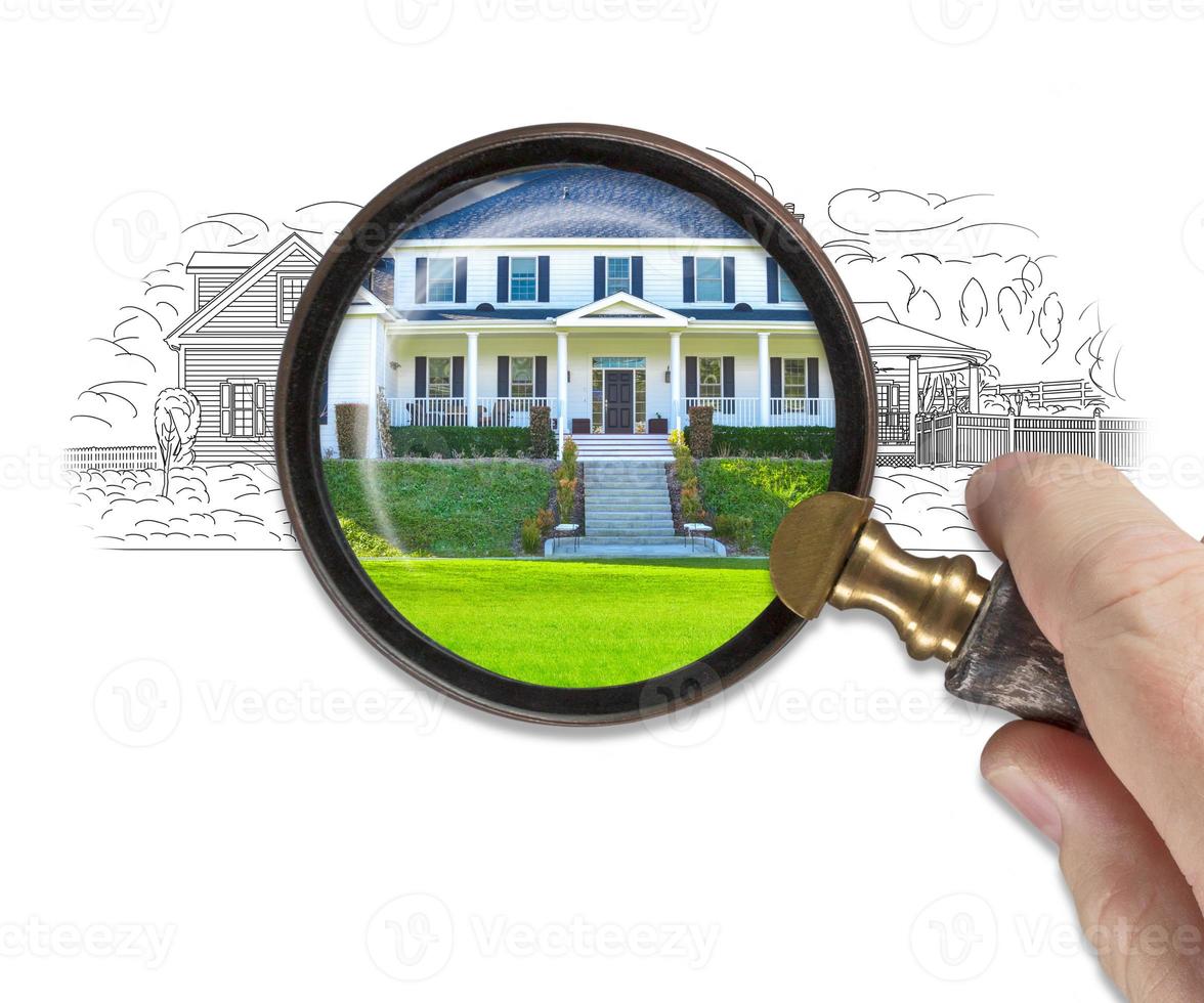 Hand Holding Magnifying Glass Revealing Finished House Build Over Drawing photo