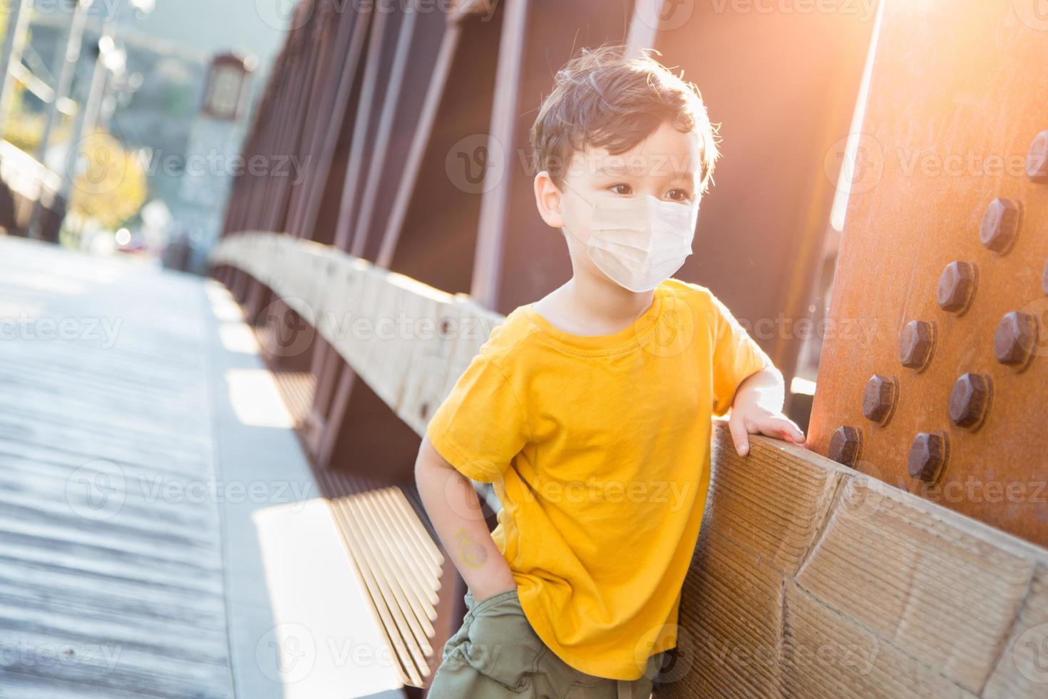 Young Mixed Race Chinese and Caucasian Boy Playing Alone Wearing Medical Face Mask Outside photo