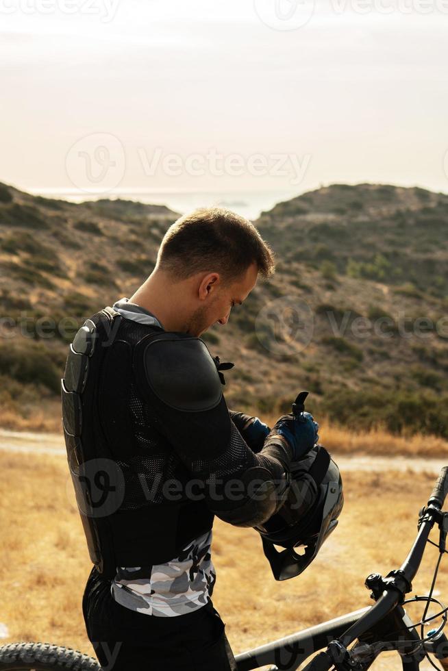 ciclista de descenso totalmente equipado con equipo de protección y su bicicleta foto