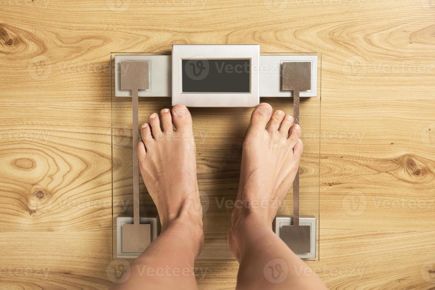 Female feet on the modern digital weighing scale photo