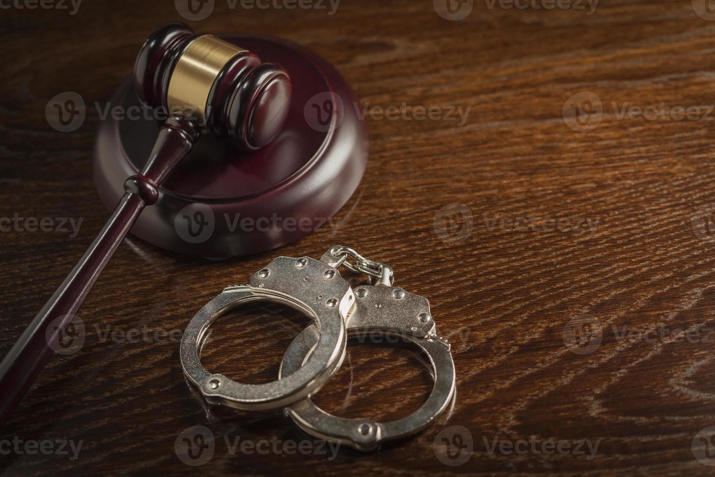 Gavel and Pair of Handcuffs on Table photo