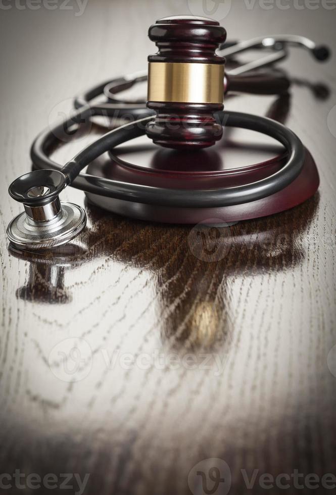 Gavel and Stethoscope on Reflective Table photo