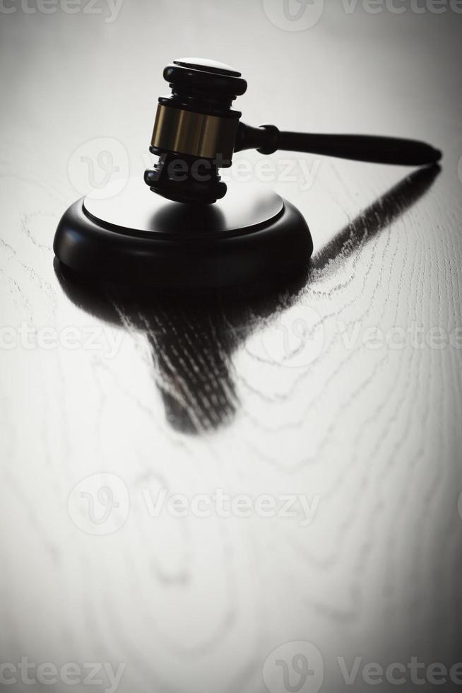 Dramatic Gavel Silhouette on Reflective Wood photo