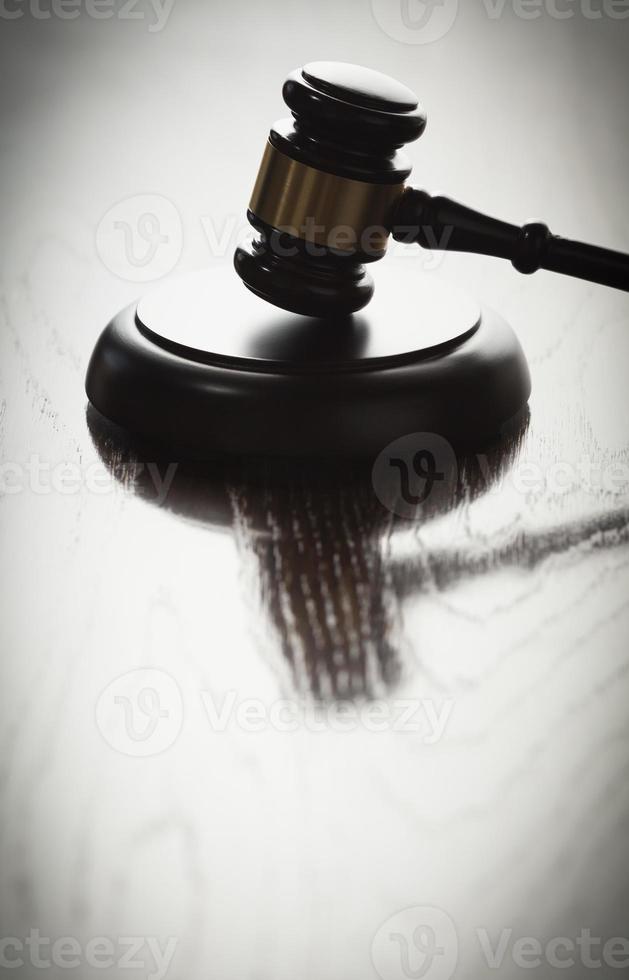 Dramatic Gavel Silhouette on Reflective Wood photo