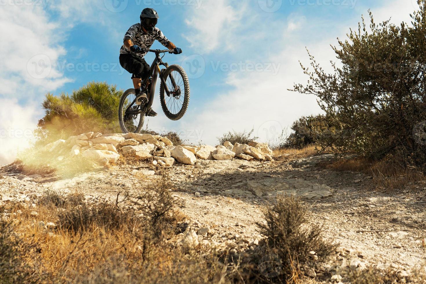 ciclista profesional saltando durante el descenso en su bicicleta foto