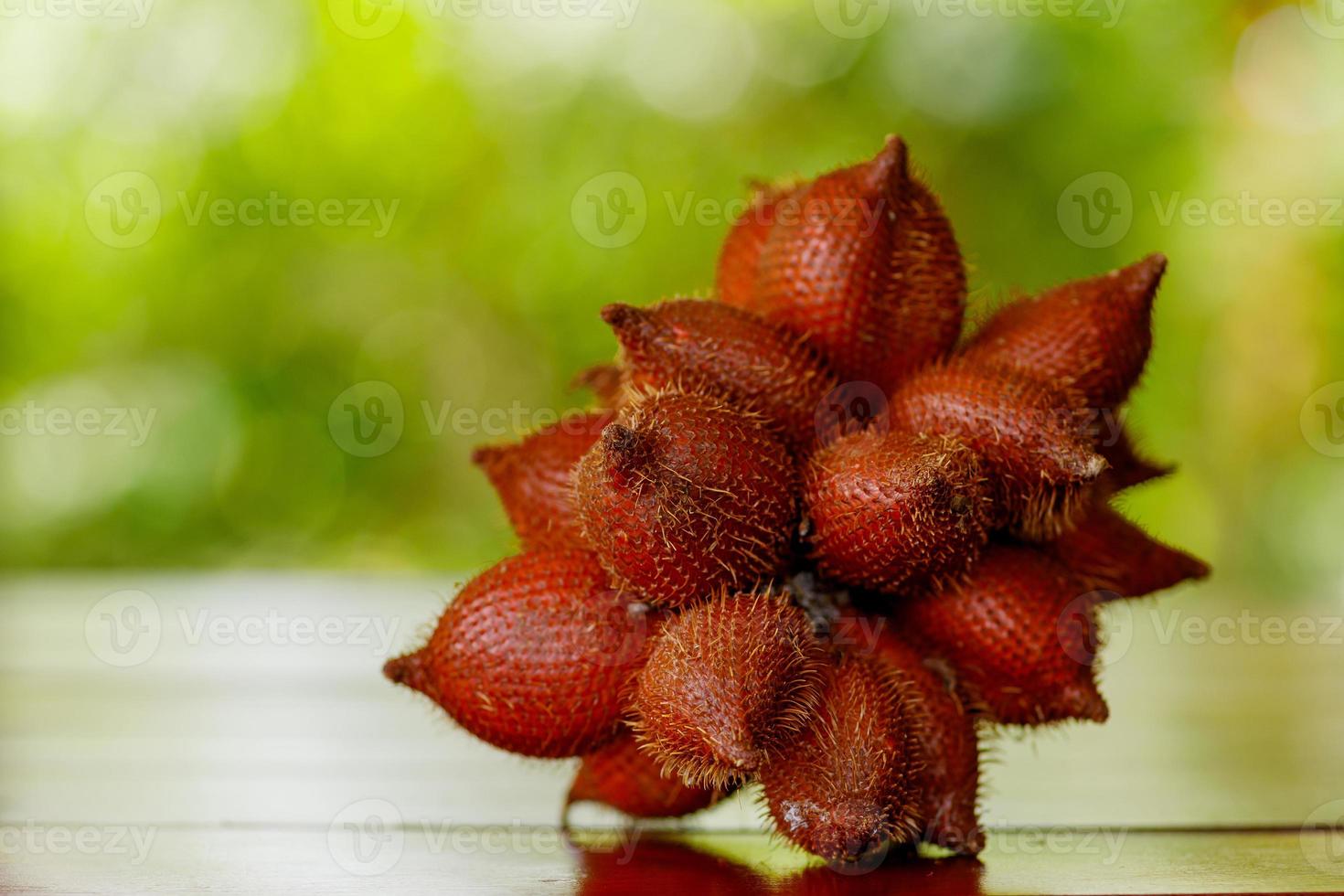 Bunch of salak snake fruit on wooden table photo