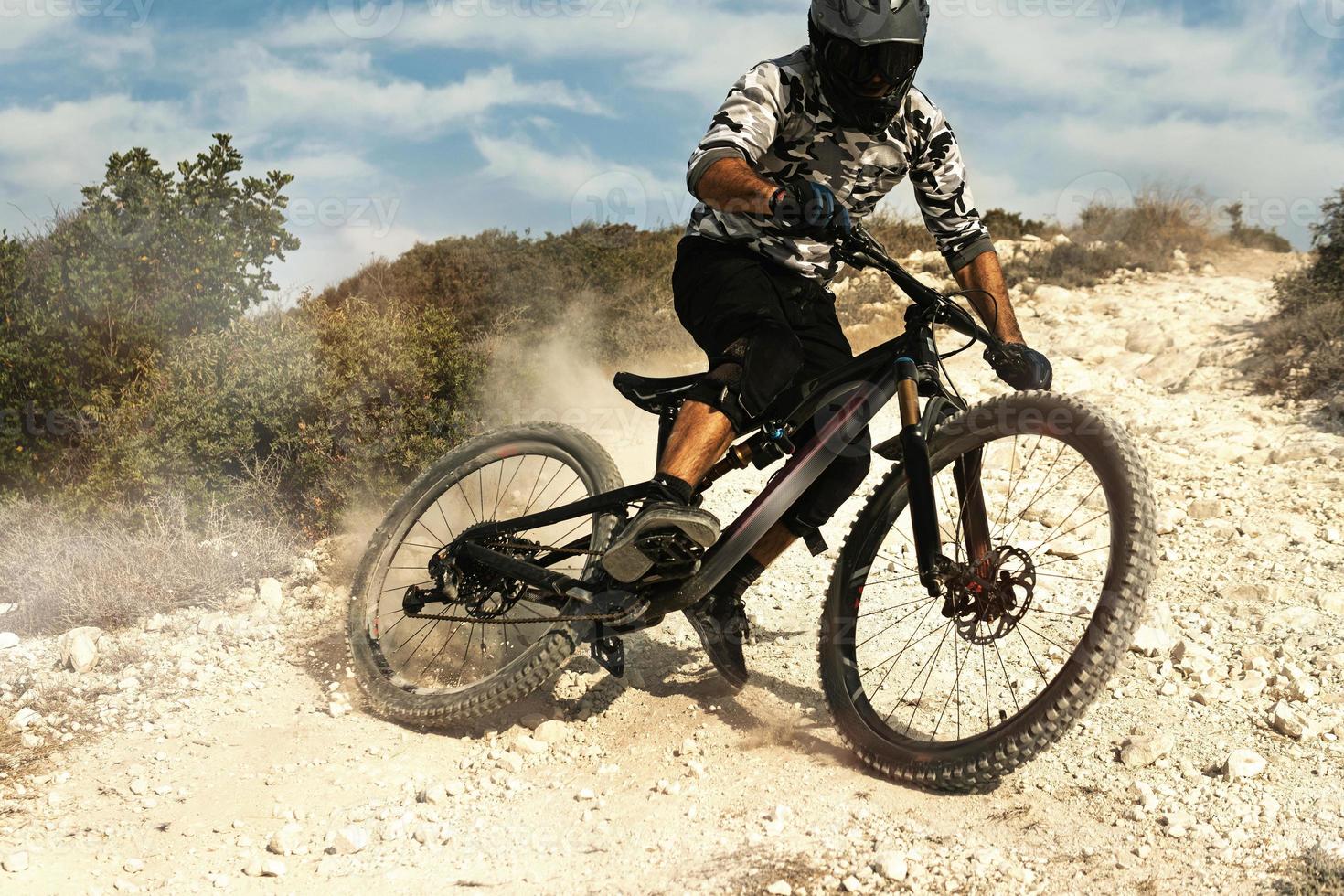 Professional bike rider during downhill ride on his bicycle photo