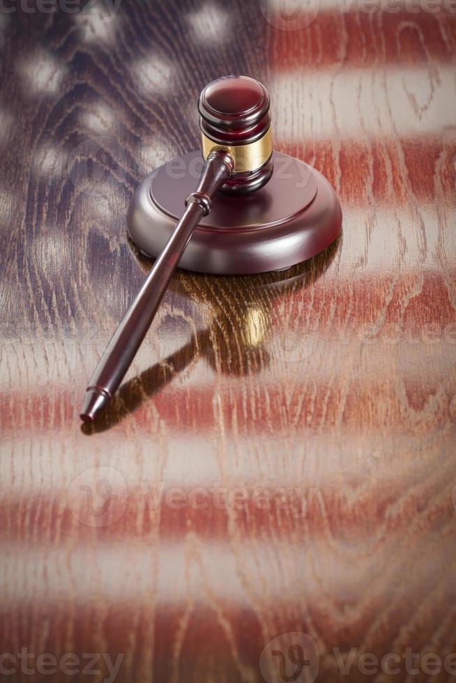 Wooden Gavel Resting on Flag Reflecting Table photo