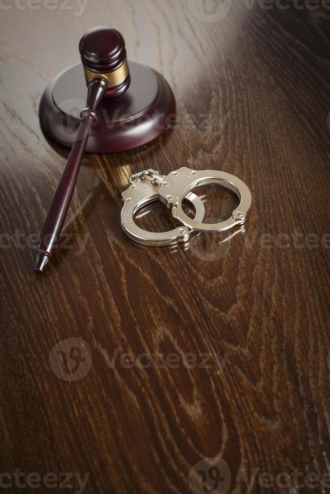 Gavel and Pair of Handcuffs on Table photo