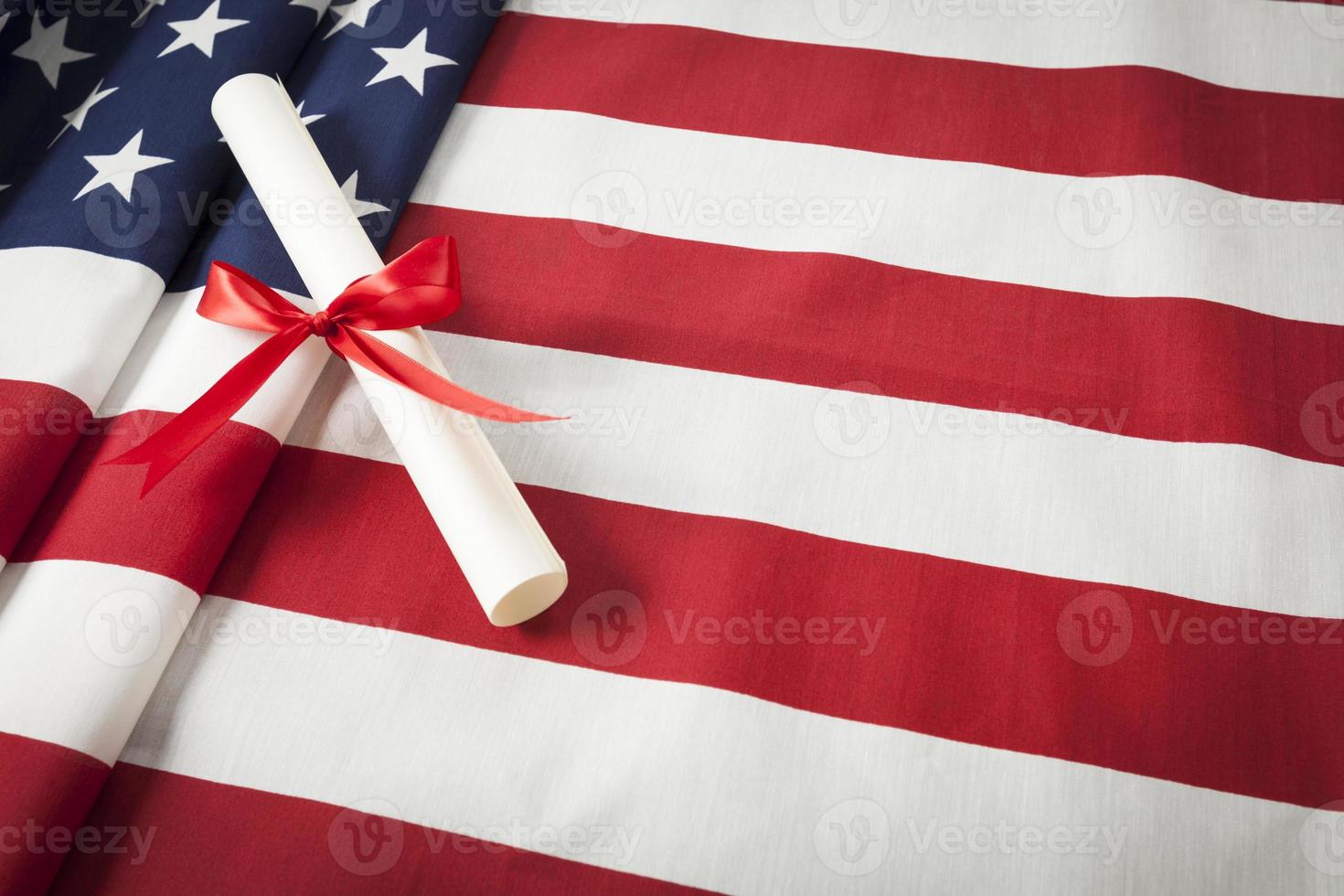 Ribbon Wrapped Diploma Resting on American Flag with Copy Space photo