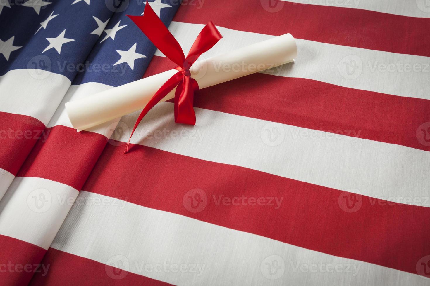 Ribbon Wrapped Diploma Resting on American Flag with Copy Space photo