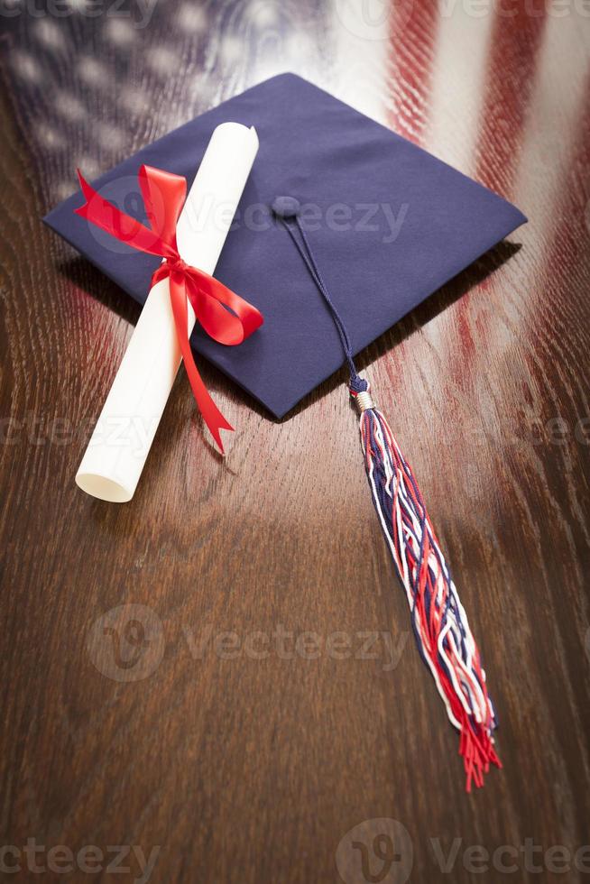 Graduation Cap and Diploma on Table with American Flag Reflection photo