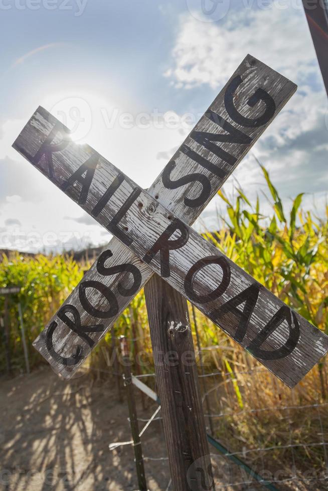 Señal de cruce de carretera de ferrocarril de país antiguo cerca de un campo de maíz foto