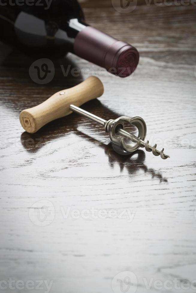 Abstract Wine Bottle and Corkscrew on Reflective Wood Surface photo