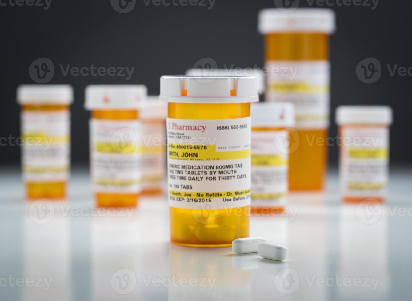 Medicine Bottles and Pills on Reflective Surface With Grey Background photo