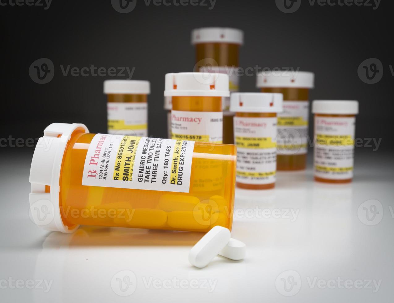 Medicine Bottles and Pills on Reflective Surface With Grey Background photo