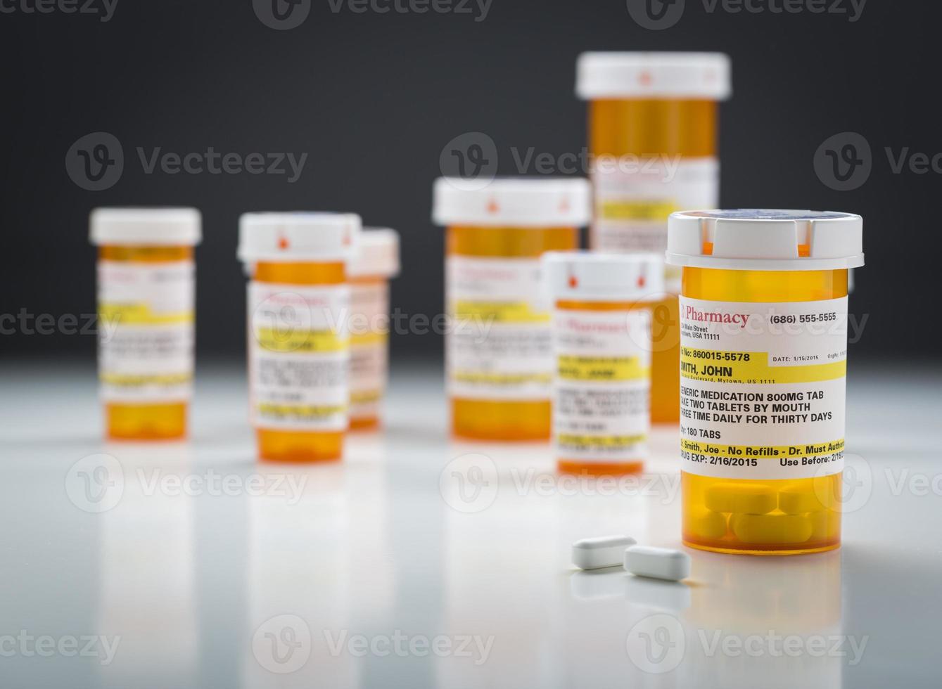 Medicine Bottles and Pills on Reflective Surface With Grey Background photo