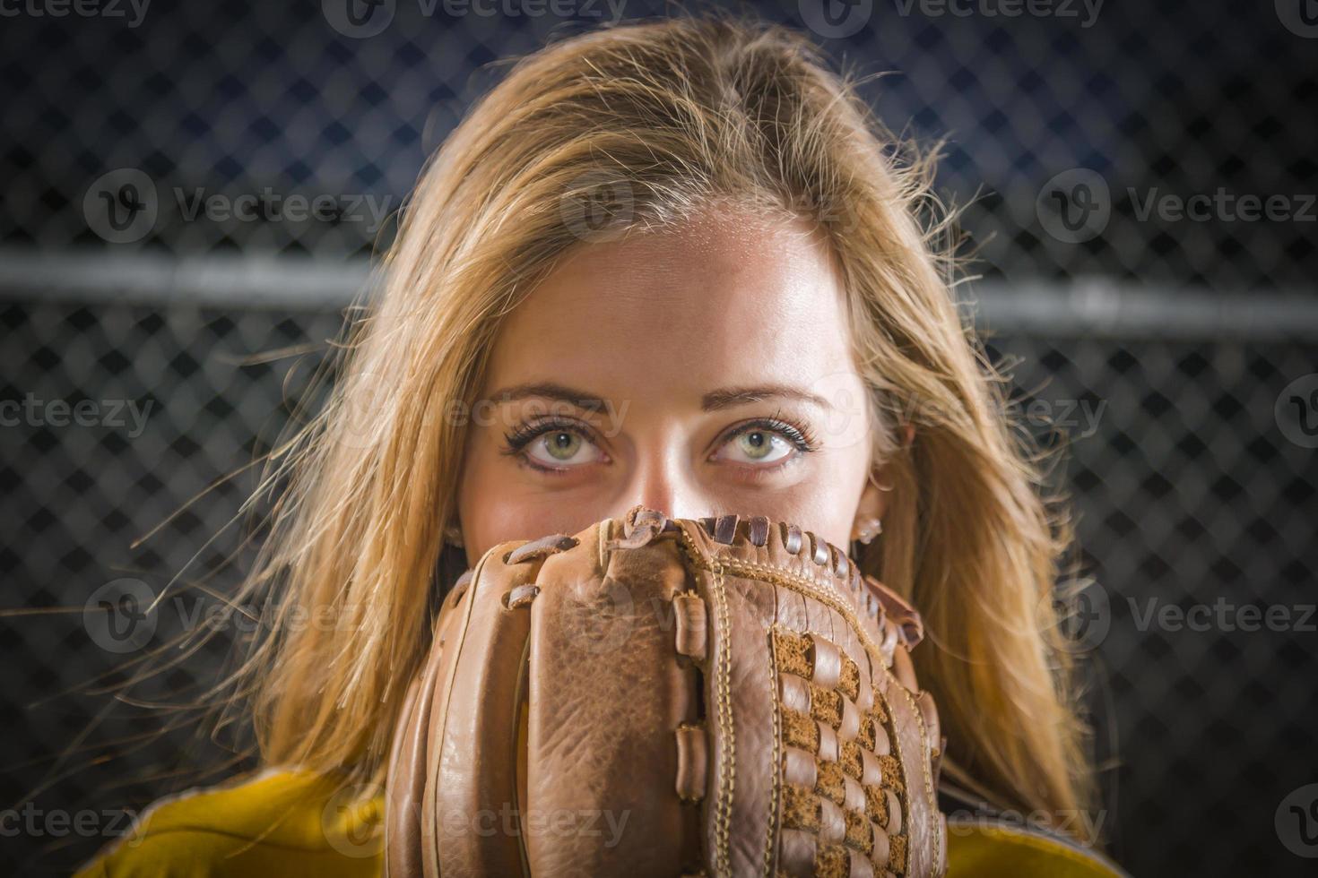 mujer joven con guante de softbol que cubre su rostro al aire libre foto