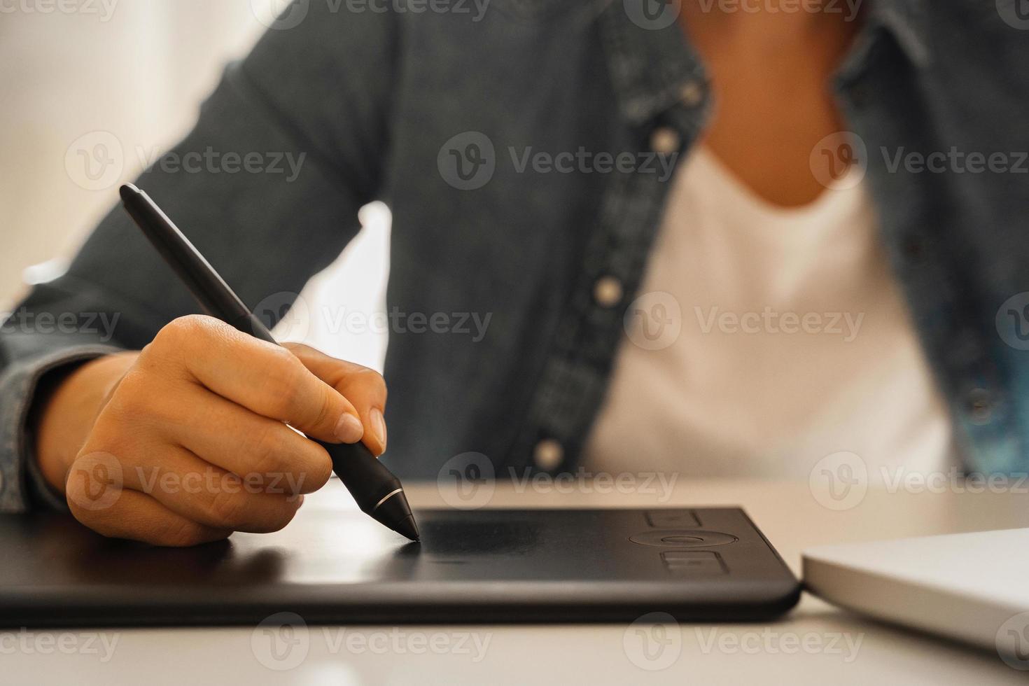 Female hand with pen-like stylus and graphic tablet photo