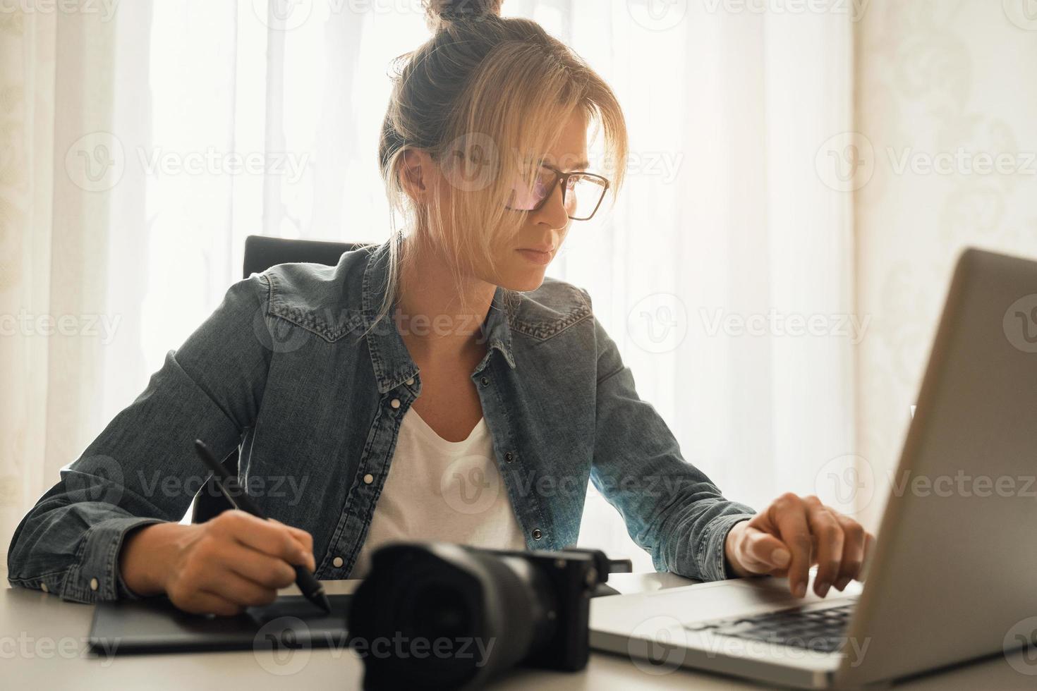 mujer fotógrafa retocando fotos usando tableta gráfica