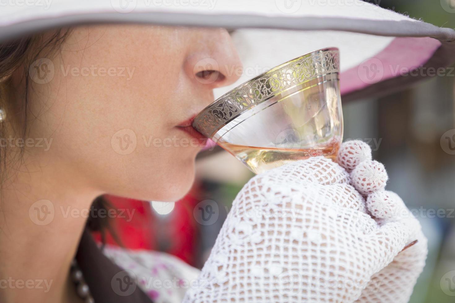 1920s Dressed Girl with Hat, Gloves and Glass of Wine photo